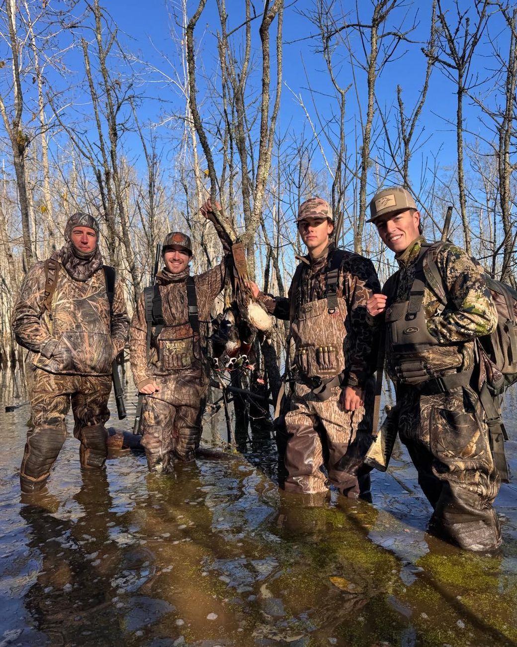 Waterfowl hunters with a limit of ducks in flooded Virginia timber
